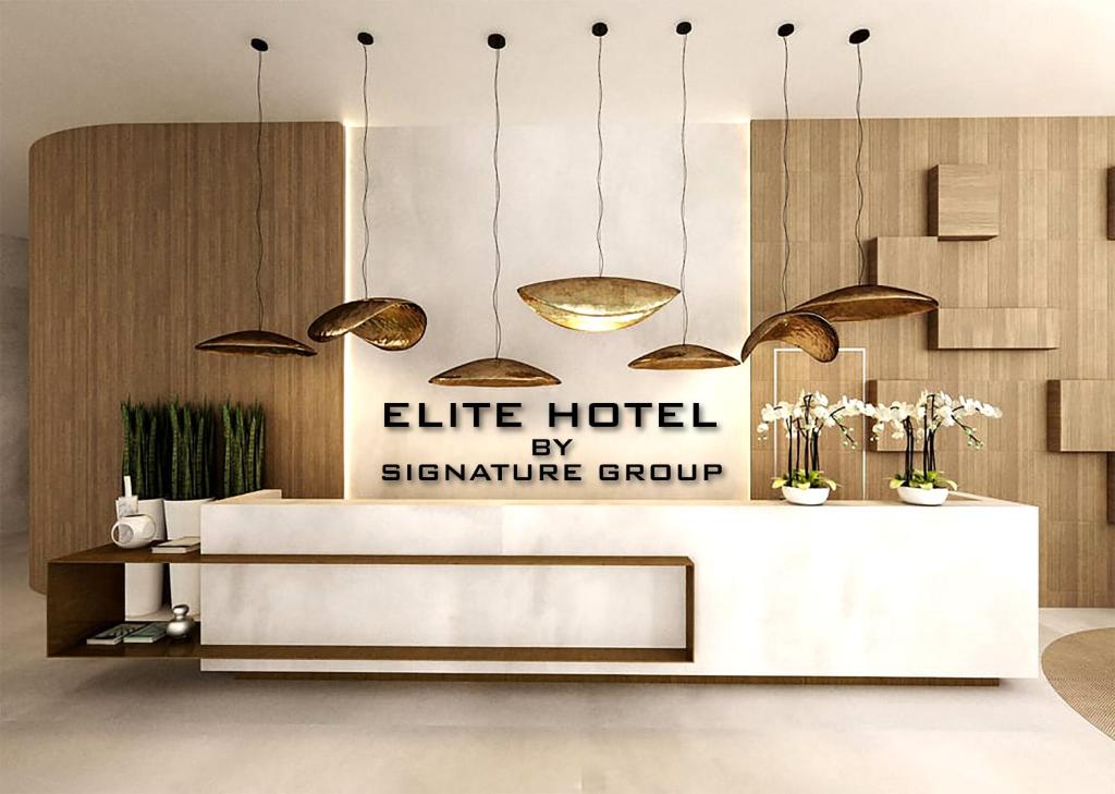 a hotel lobby with a reception desk and pendant lights at Hotel Elite By Signature Group in Hyderabad