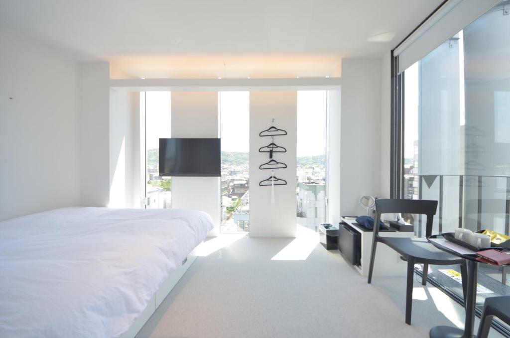 a bedroom with a bed and a desk and a tv at Carta Hotel Kyoto Gion in Kyoto