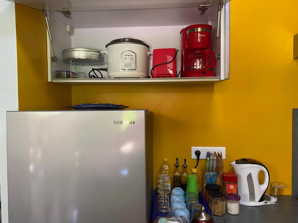 a refrigerator in a kitchen with a shelf at Tiki House in Bora Bora