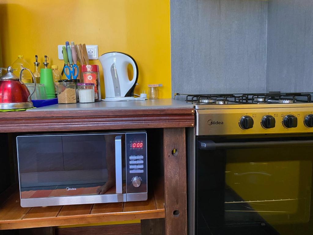 a microwave sitting on a wooden counter next to a stove at Tiki House in Bora Bora