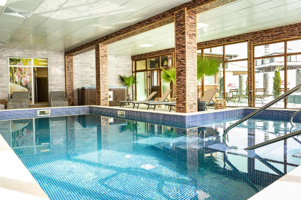 uma piscina com azulejos azuis no chão e janelas em Zarevata Guest House em Velingrad