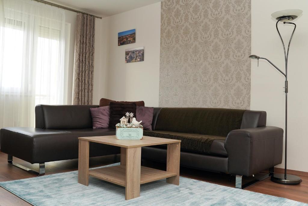 een woonkamer met een bank en een salontafel bij The Pearl of Zsofia in Esztergom