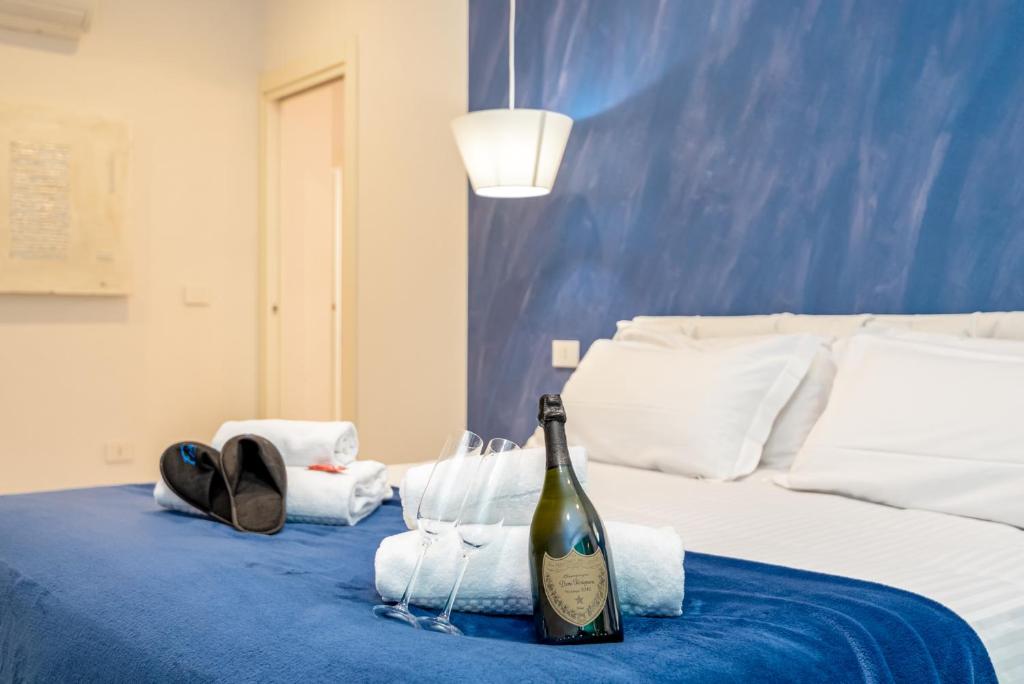 a bottle of wine sitting on a bed with towels at Appartamento Rina in Levanto