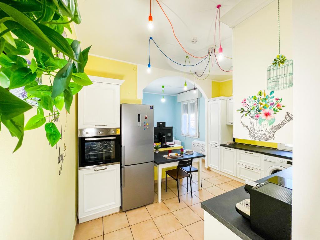 a kitchen with a refrigerator and a table at Da Birba a Casinalbo Affitti Brevi Italia in Casinalbo