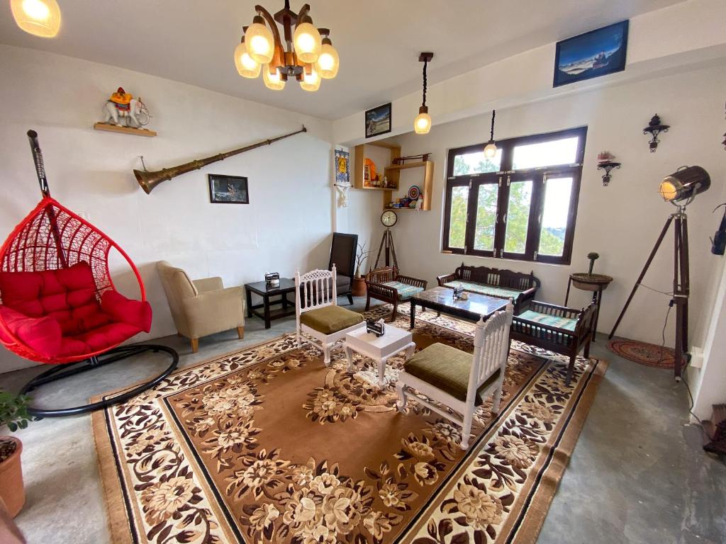 a living room filled with furniture and a table at Redeem Cafe & Homestay in McLeod Ganj