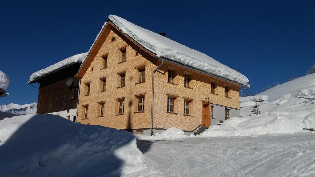 a building covered in snow with a pile of snow at Pfefferhütte in Marul