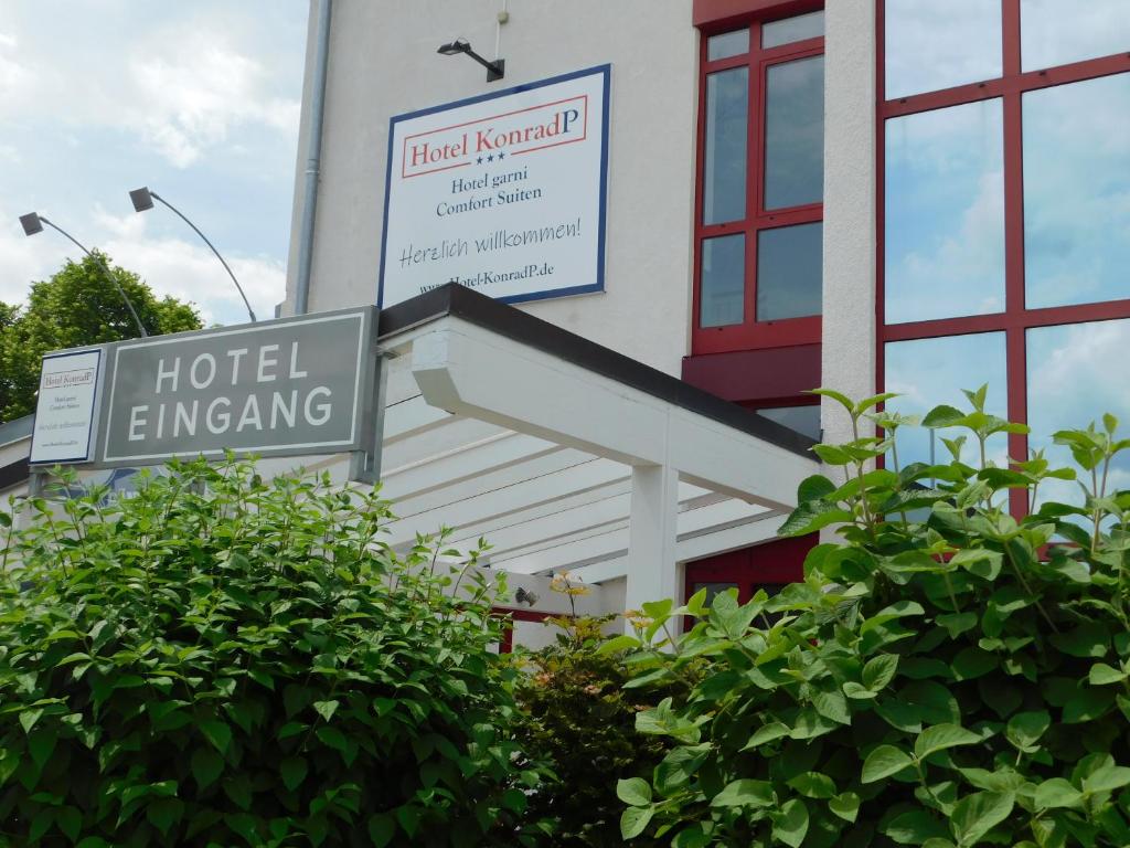 a hotel entrance sign in front of a building at Hotel KonradP Holzkirchen in Holzkirchen