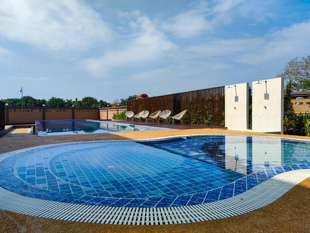 a large swimming pool with blue tiles on the ground at Lueangchan Orchid Hotel in Chanthaburi