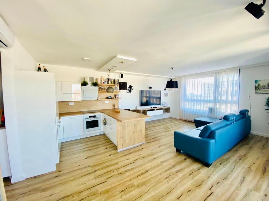 un soggiorno con divano blu e una cucina di 2 luxury rooms with SCENIC view in City Park Ruzinov a Trnávka