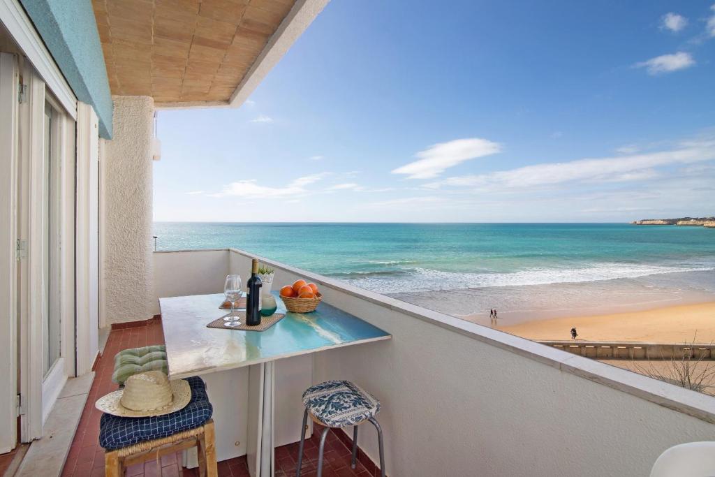 a balcony with a table and a view of the beach at Apartamento Caravela in Armação de Pêra