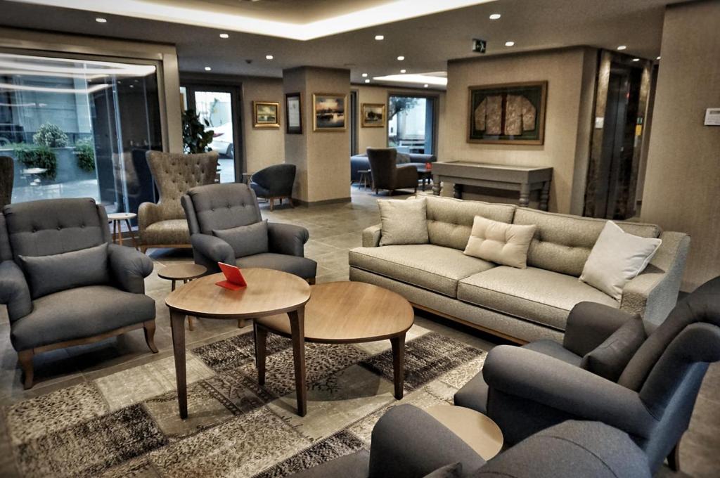 a living room with couches and chairs and a piano at Eresin Hotels Express in Istanbul