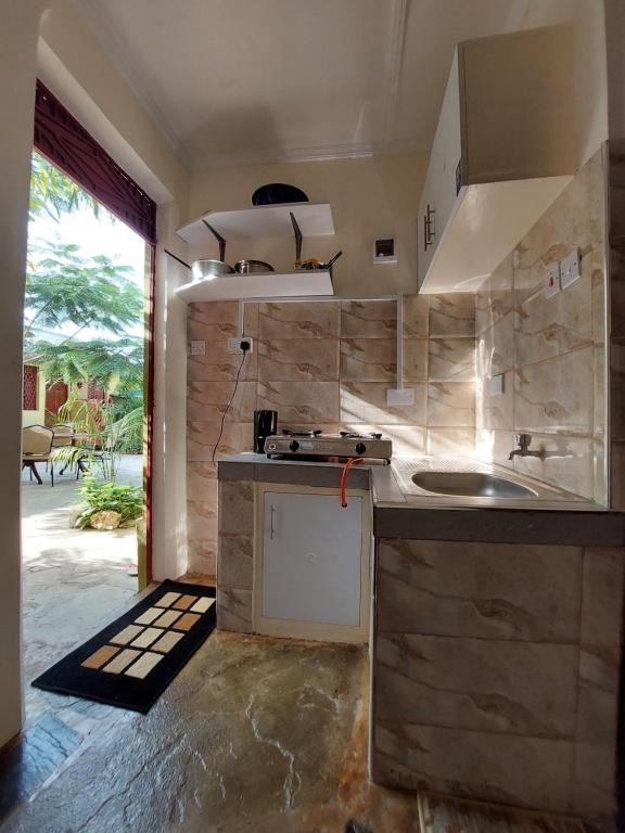 uma cozinha com um lavatório e uma bancada em Amarossi Rhino-Studio Terrace Apartment,Mtwapa em Mtwapa
