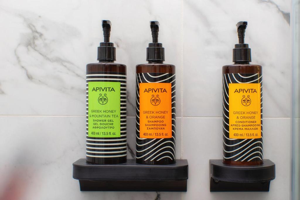 three bottles of shampoo sitting on a wall at ARCHONTARIKI Historic Boutique Hotel in Ioannina