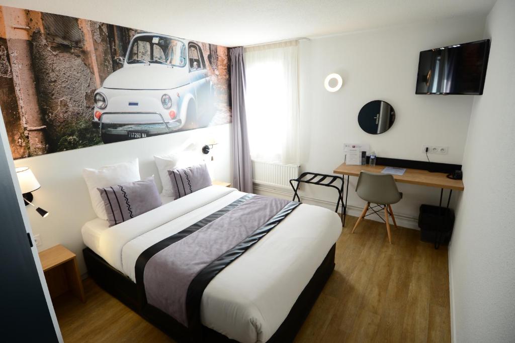 ein Schlafzimmer mit einem Bett mit einem Bild eines Autos an der Wand in der Unterkunft Logis Cris Hôtel, Lyon Est in Corbas