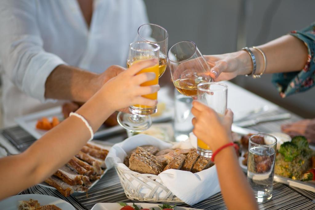 a group of people drinking wine at a table with food at Spa Resort Luxury Apartments in Budva
