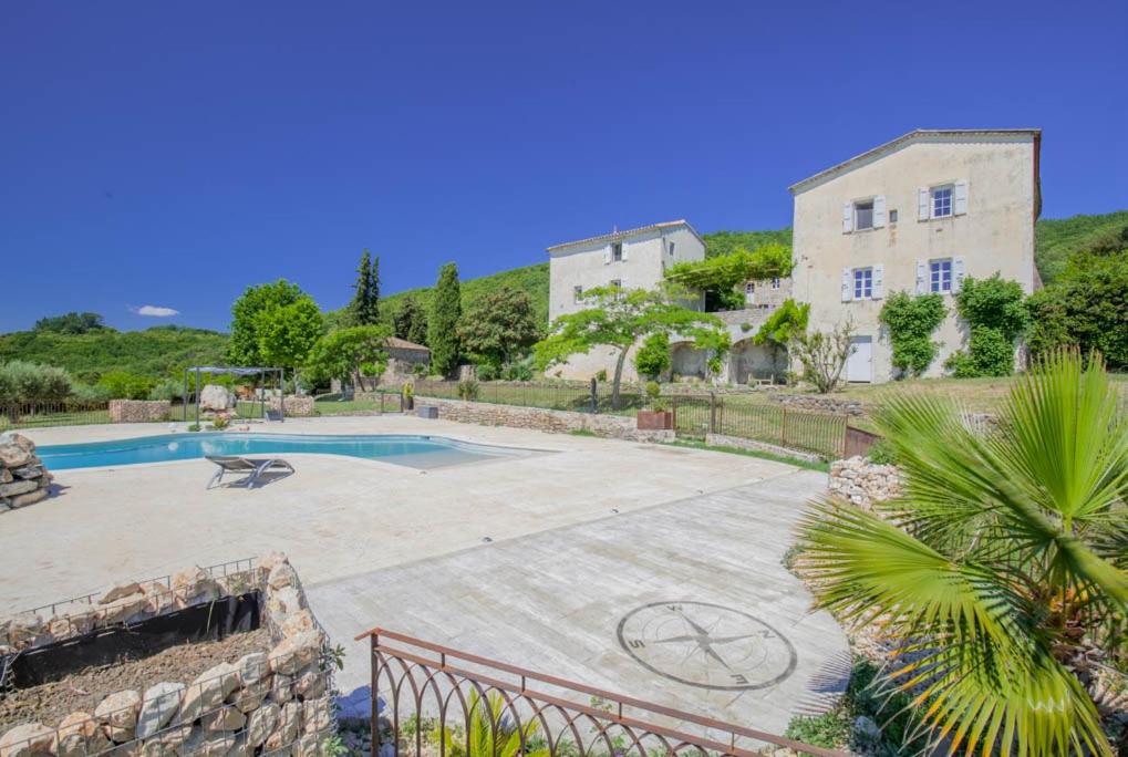 a villa with a swimming pool and a building at Gîte - Mas de Louise in Rousson