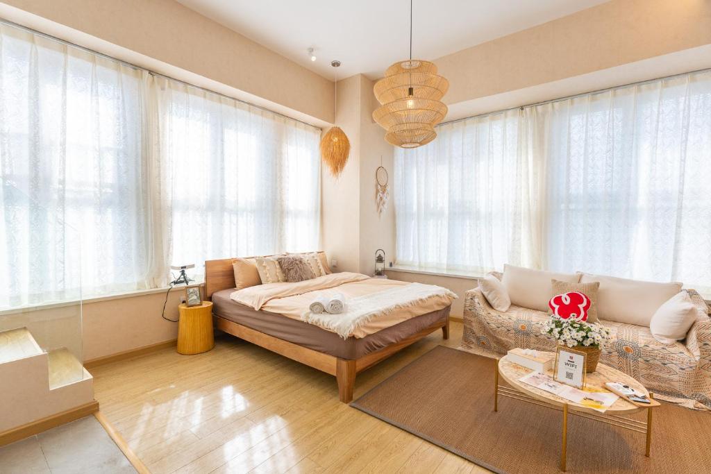 a bedroom with a bed and a couch and a table at Locals Apartment Inn 16 in Jiang'an