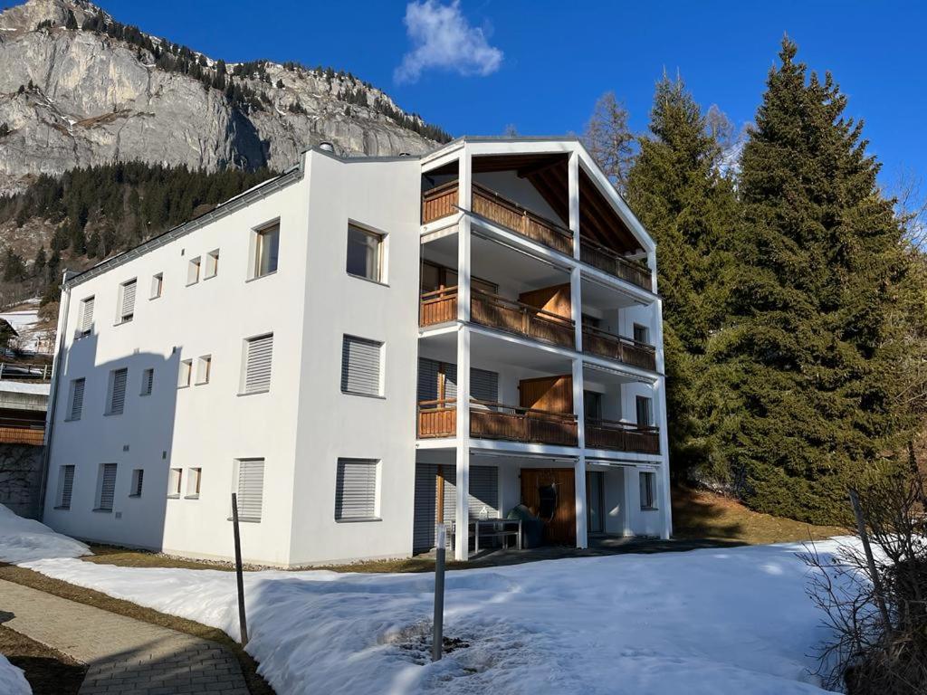 弗利姆斯的住宿－Spacious apartment up to 6 people in Flims，一座白色的大建筑,地面上积雪