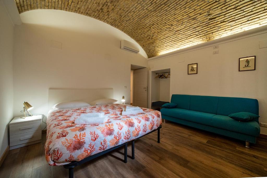 Un dormitorio con una cama y un sofá verde. en appartamento Porta Pia, en Roma