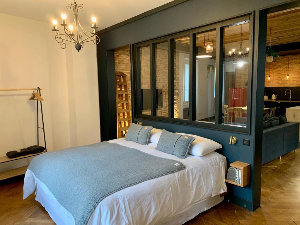 a bedroom with a large bed with blue and white sheets at The Loft, by So & Dam’s in Thonon-les-Bains