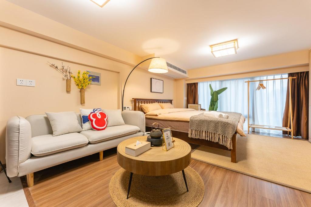 Locals Apartment Inn 38 في Jiang'an: غرفة معيشة مع أريكة وسرير