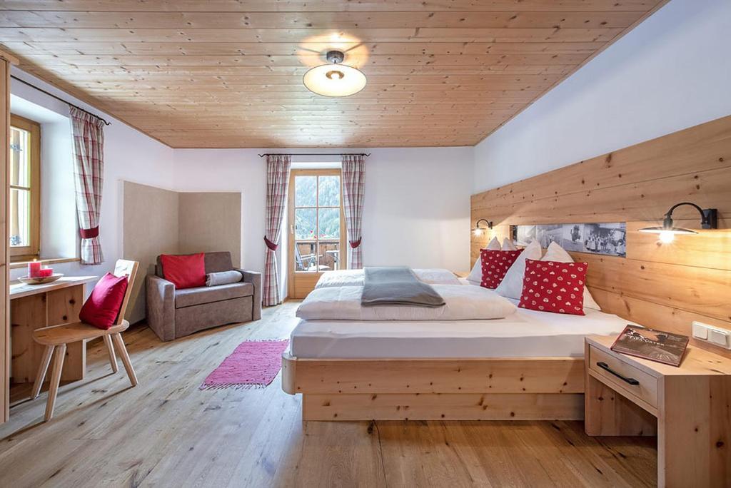 ein Schlafzimmer mit einem großen Bett und einer Holzdecke in der Unterkunft Oberglarzhof App Zirbel in Villnöß