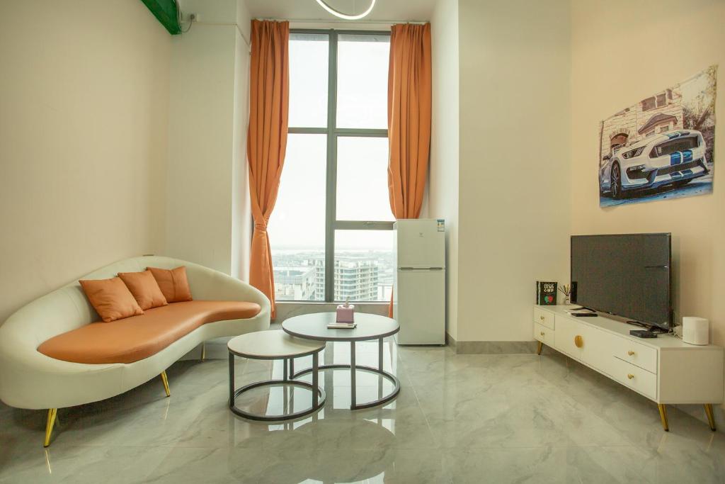 a living room with a couch and a tv at Locals Apartment Place 44 in Zhanjiang