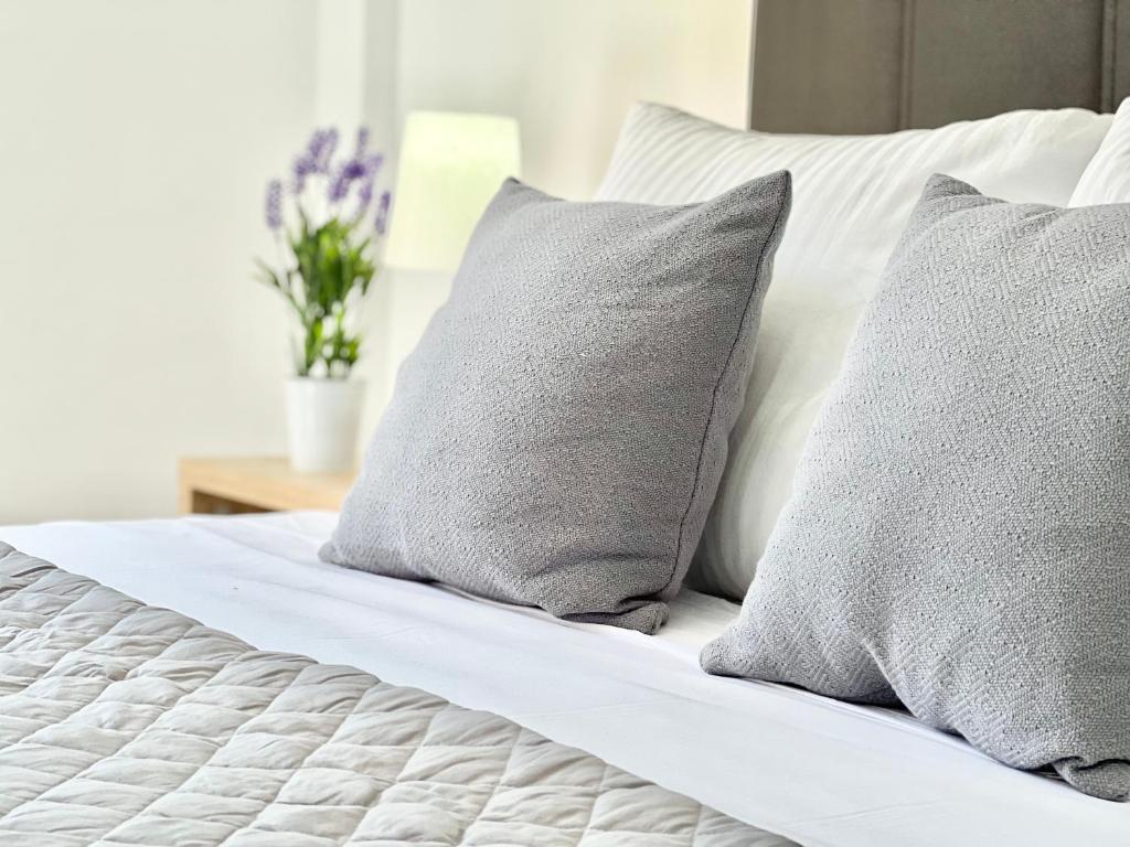 a bed with grey pillows and a white sheet at Apartamentos Zaragoza in Salou