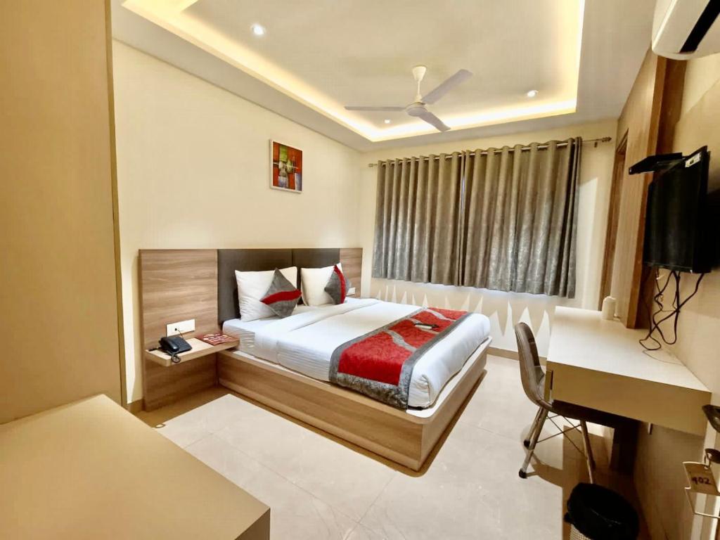 a hotel room with a bed and a desk and a computer at Hotel Tripple Tree - Karol Bagh in New Delhi