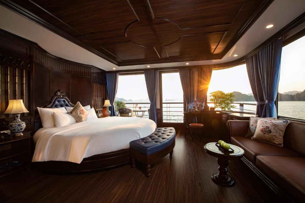 La Casta Regal Cruise في ها لونغ: غرفة نوم بسرير كبير وأريكة
