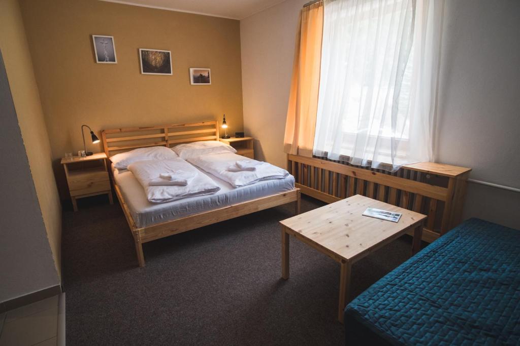1 dormitorio con cama, mesa y ventana en Penzion Zornicka en Donovaly