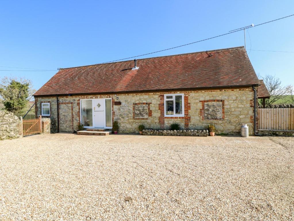 a brick house with a driveway in front of it at Stable Cottage in Newport