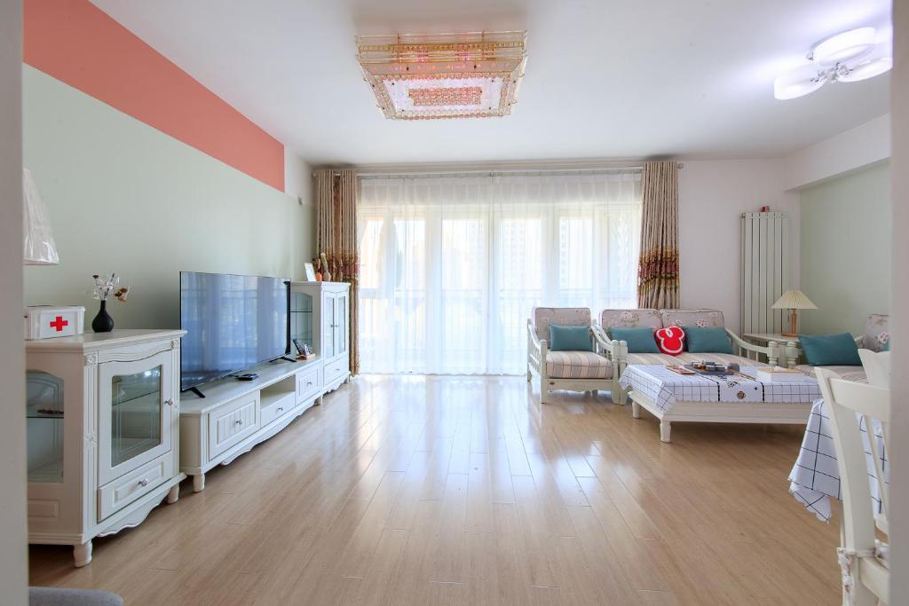 a living room with a couch and a tv at Locals Apartment Inn 14 in Tianjin