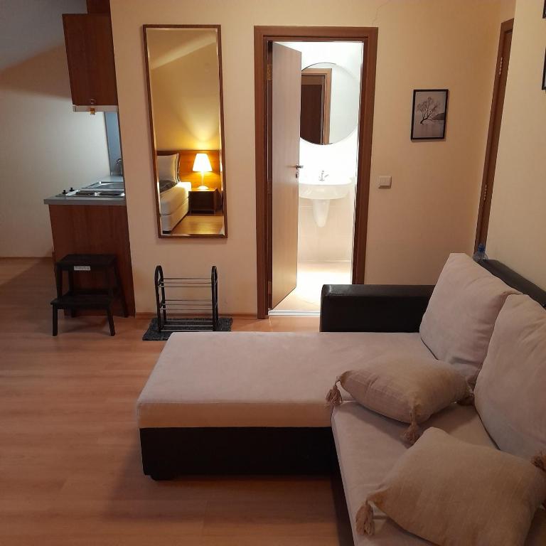 a living room with a couch and a mirror at Studio Villa Park 410 in Borovets