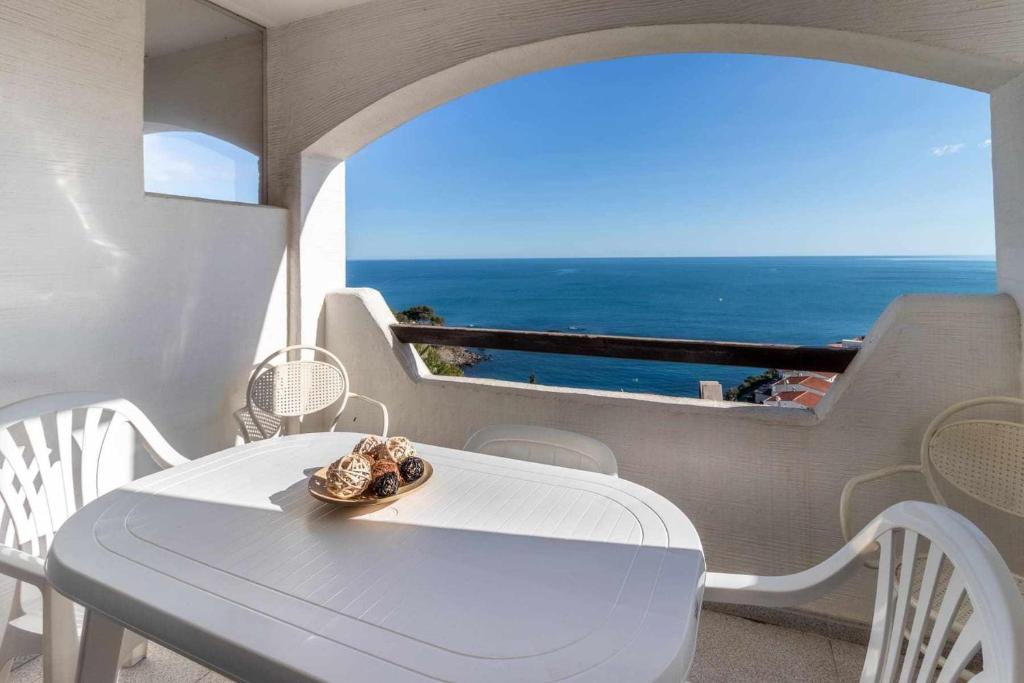 - une table et des chaises blanches avec vue sur l'océan dans l'établissement Cau del Llop 76 apartamento piscina comunitaria, à Gérone