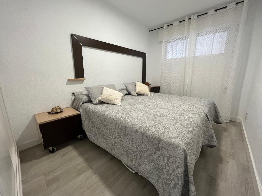 Un dormitorio con una cama con un espejo grande. en TAO 1 Primera línea de Playa VELILLA, en Almuñécar