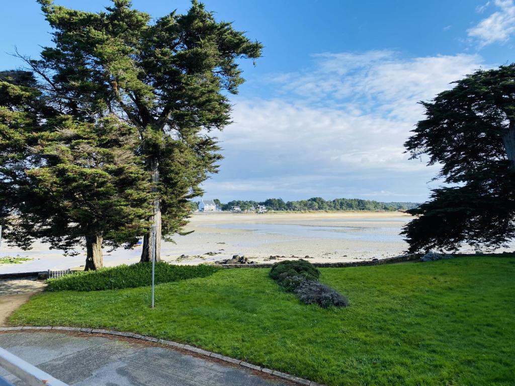 - une vue sur la plage avec des arbres et l'eau dans l'établissement BEAUMER - Men Dû, Parking, Wifi - UD96, à Carnac