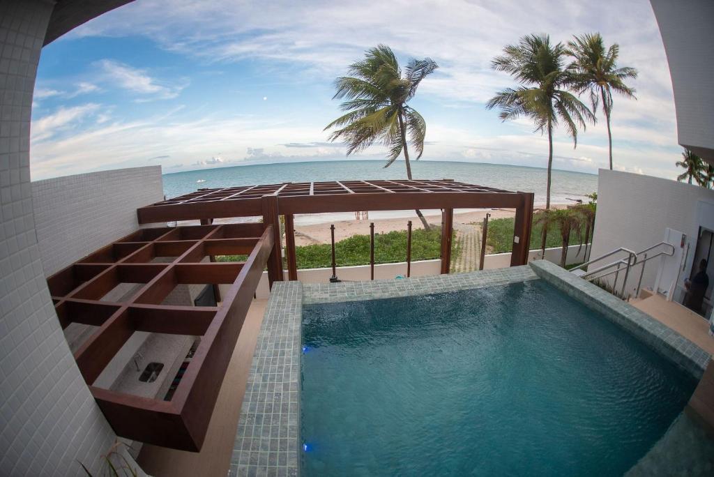 una piscina con vista a la playa en Branco Haus - Pé na Areia do Caribessa, en João Pessoa