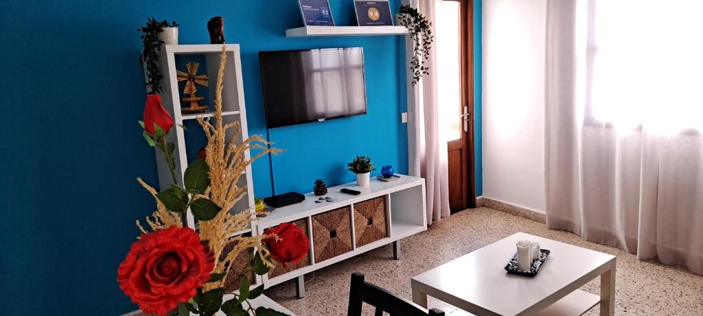 a living room with a table and a tv on a blue wall at Molinos II - Casitas Las Abuelas in Santa Cruz de la Palma