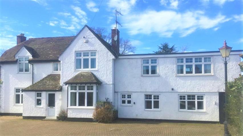 une maison blanche avec des fenêtres blanches et une allée. dans l'établissement Dove House, à Cheltenham