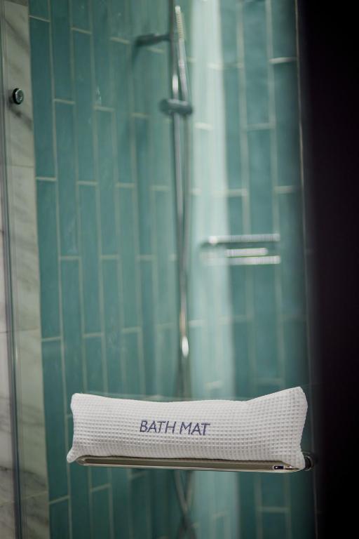 a towel that says bath mat sitting in a shower at The Parkgate Hotel in Cardiff