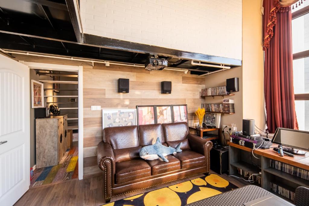 a living room with a leather couch and a desk at Locals Apartment House 00 in Tianjin