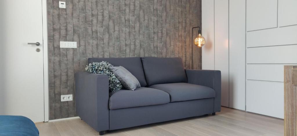 a blue couch sitting in a living room at Bed & Wellness Boxtel, luxe kamer met airco en eigen badkamer in Boxtel