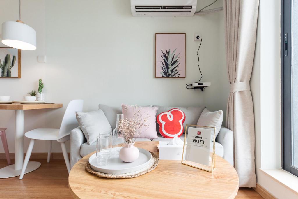 a living room with a table and a couch at Vanke Apartment Guangzhou South Railway Station Vanke Expo Expo Expo Olympic Park yueshidai square Changlong happy world in Guangzhou