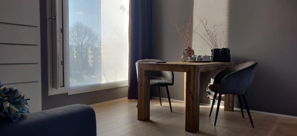 a table and chairs in a room with a window at Bed & Wellness Boxtel, luxe kamer met airco en eigen badkamer in Boxtel