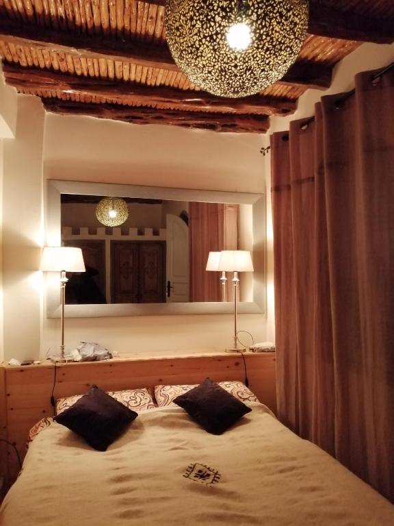 une chambre avec un lit et un grand miroir dans l'établissement Dar Farah, riad au coeur de la médina, à Essaouira