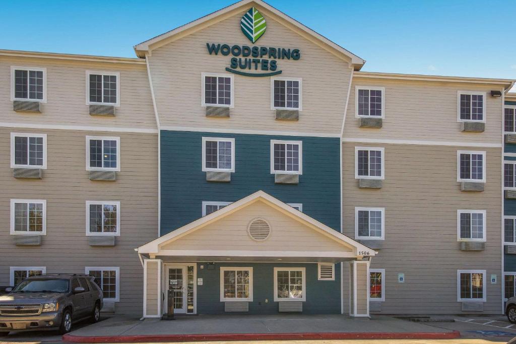 ein Gebäude mit einem LKW, der davor parkt in der Unterkunft WoodSpring Suites Houston La Porte in La Porte