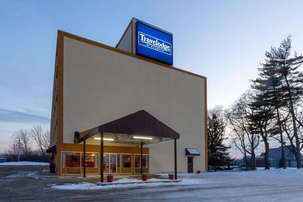 a building with a sign on the side of it at Travelodge by Wyndham Cleveland Airport in Brook Park