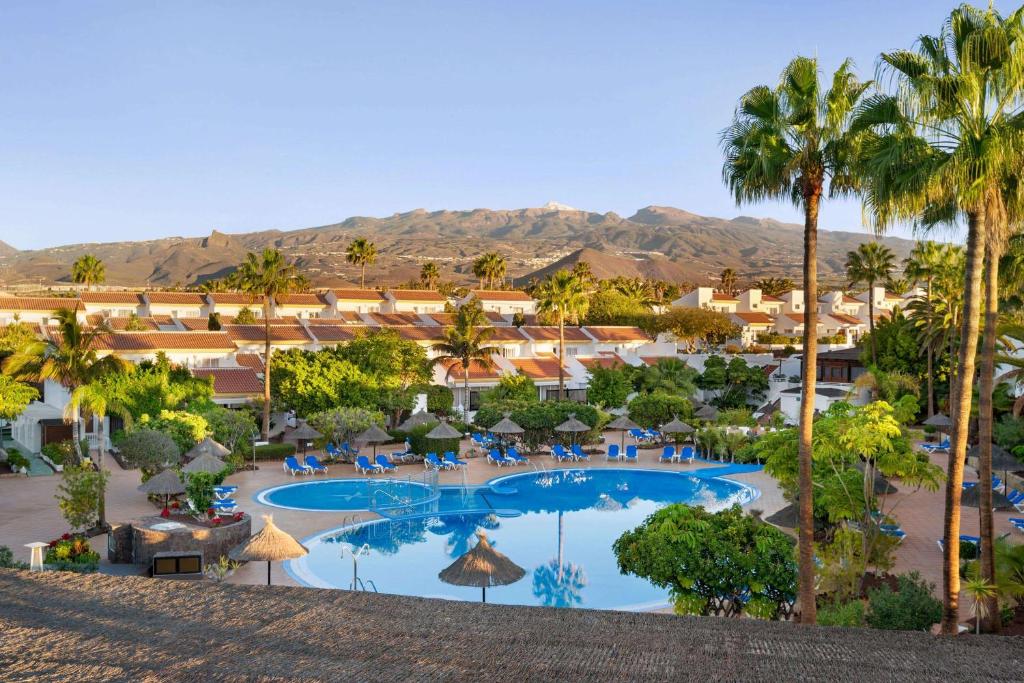 ein Luftblick auf ein Resort mit einem Pool und Palmen in der Unterkunft Wyndham Residences Golf del Sur in San Miguel de Abona