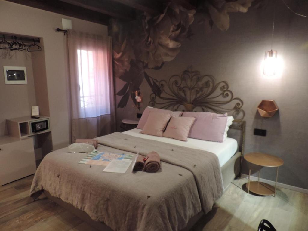1 dormitorio con 1 cama grande con almohadas rosas en Al Sagraeto, en Chioggia